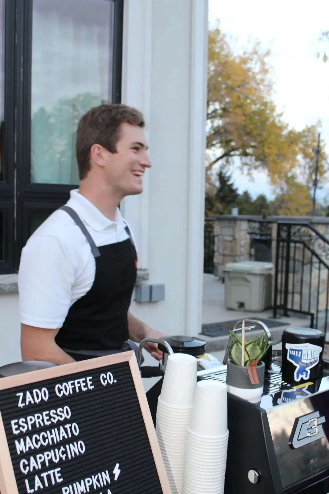 A Zado barista laughing behind the cart