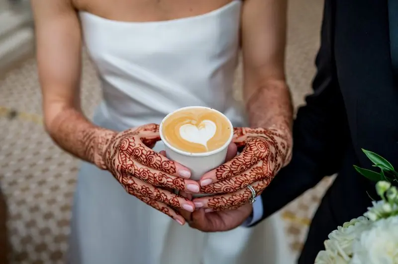 A bride holding a latte with a heart poured on top