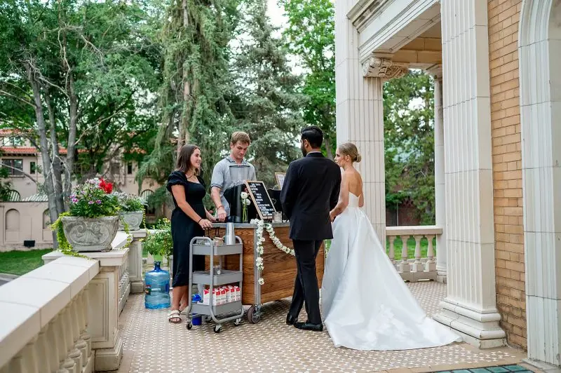 A bride and groom at the Zado cart on a venue veranda
